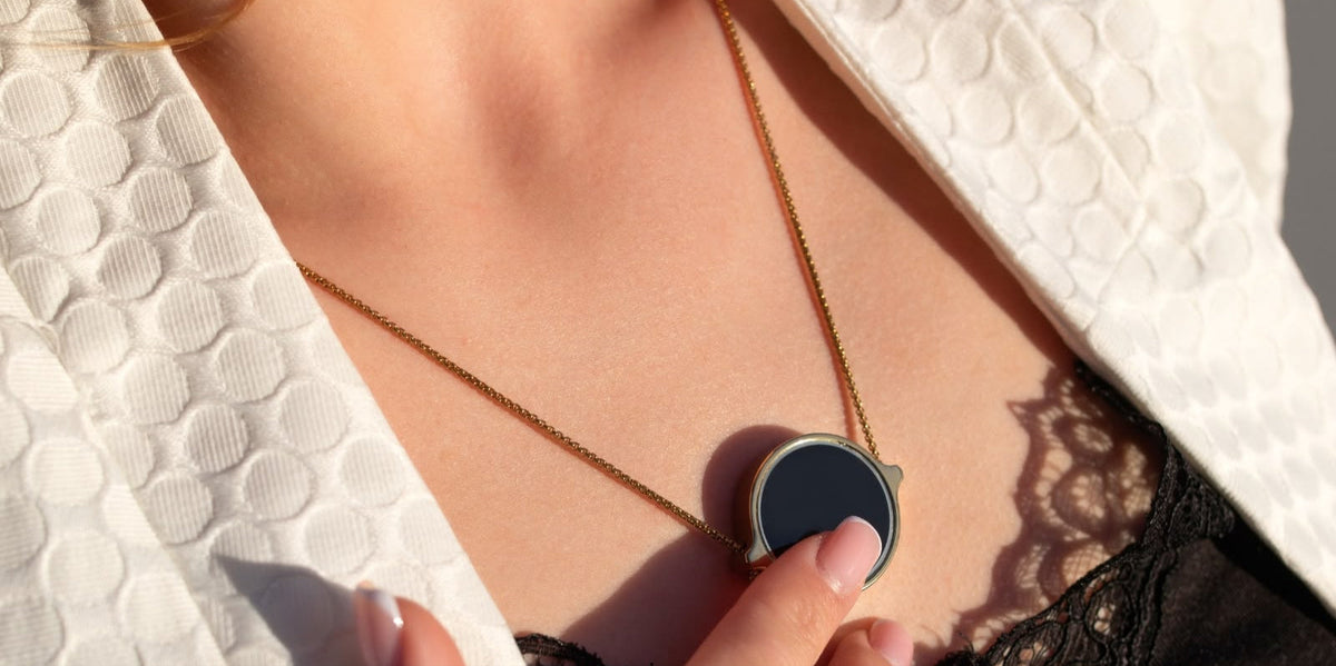 Frau im Alltag mit ThymusSmart® Kette, Finger auf dem Pendant im Brustbereich